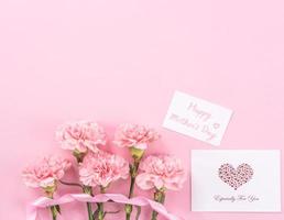 vista superior, capa plana, espacio de copia, primer plano, maqueta, concepto de diseño de agradecimiento del día de la madre. hermosos claveles de color rosa bebé frescos y florecientes aislados en un fondo rosa brillante