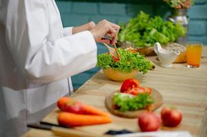 mano del chef, cocinando ensalada de verduras, concepto de cocina saludable