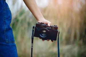 mano y cámara del fotógrafo sosteniendo y llevando la cámara para tomar fotografías foto