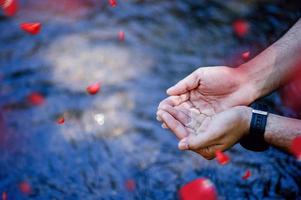 Hands and water flowing from natural waterfalls Water concept from natural waterfall photo