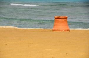 bote de basura de arcilla en la playa foto