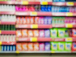 estantes de detergente en supermercado o tienda de comestibles fondo borroso foto