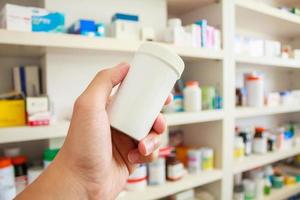 hand hold medicine bottle in the pharmacy photo