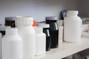 Bottles of pills arranged on shelf at drugstore photo