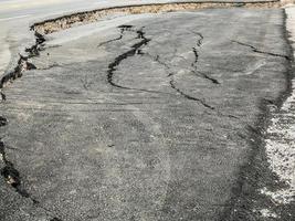 asphalt road cracked and broken texture photo