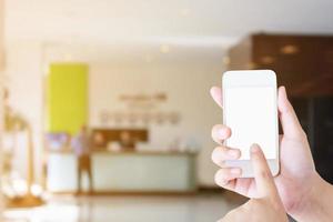 woman hand hold mobile smartphone with hotel lobby photo