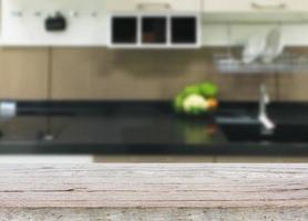 Empty wooden table and blurred kitchen background photo