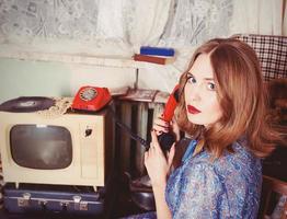 portrait of Old fashioned woman in USSR style talking on the old telephone in retro interior photo