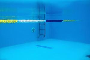 View of the swimming pool with metal ladder underwater photo