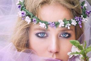 beautiful young blonde woman in flower wreath blooming trees in spring photo