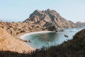 View of the hills and coast and several sailing boats on Padar Island photo