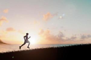 silueta de hombre corriendo en el atardecer. silueta para un corredor entrenando por la noche. puestas de sol foto