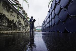 Registro de inspección del trabajador masculino barriles de stock de aceite de tambor azul horizontal o químico foto