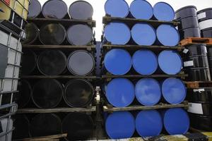 barriles de petróleo azules y negros o tambores químicos apilados horizontalmente. foto