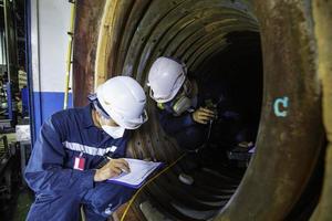 la inspección de dos trabajadores masculinos midió el espesor circular del tubo de la bobina del espesor mínimo de escaneo de la caldera foto