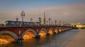 burdeos, francia, 2016. tranvía pasando por el pont de pierre cruzando el río garona en burdeos foto