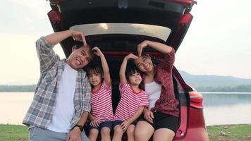 Happy family enjoying road trip on summer vacation. The family travels on the road in their favorite car. Holiday and travel family concept. video