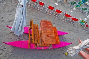 Shore beach with sun umbrella and deckchairs photo