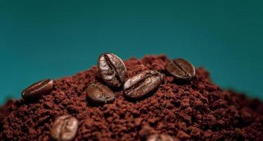 Coffee beans on a pile of ground coffee powder