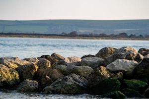 Seaweed covered rock Groyne at sunset photo