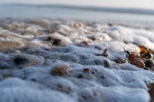 Waves over washed up sea shells photo