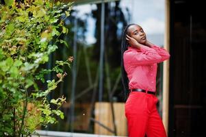 Pretty braids business african american lady bright bossy person friendly wear office red shirt and trousers. photo