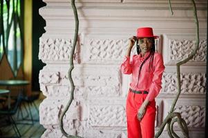 Pretty braids business african american lady bright bossy person friendly wear office red shirt, hat and trousers. photo