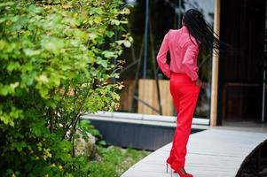 Pretty braids business african american lady bright bossy person friendly wear office red shirt and trousers. photo