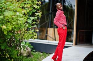 Pretty braids business african american lady bright bossy person friendly wear office red shirt and trousers. photo