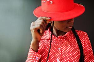 Close up portrait of pretty braids business african american lady bright bossy person friendly wear office red shirt and hat. photo