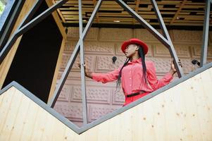 Pretty braids business african american lady bright bossy person friendly wear office red shirt, hat and trousers. photo