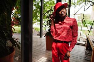 Pretty braids business african american lady bright bossy person friendly wear office red shirt, hat and trousers. photo