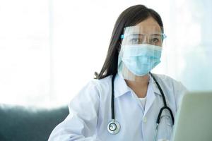 doctora asiática que trabaja en el consultorio médico del hospital. doctor colgando un estetoscopio sobre su cuello. foto