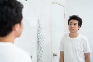 Asian young man brushing his teeth. photo