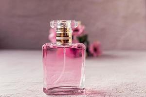 frasco de perfume rosa con flores rosas foto