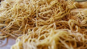 Yellow noodles in a tray on the kitchen table photo