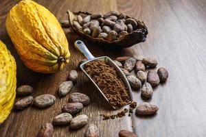 cacao en polvo y cacao en grano sobre mesa de madera foto