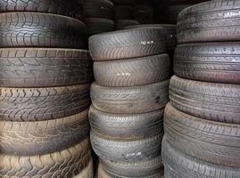 montones de neumáticos de automóviles usados que han sido reparados y listos para la venta foto