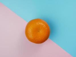 concepto creativo hecho de naranja sobre fondo azul y rosa pastel. concepto de fruta sana y mínima foto