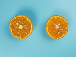 Creative concept made from oranges on blue pastel background. healthy and minimal fruit concept photo