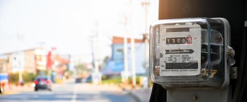 medidor de vatios-hora de electricidad colgado en el poste de cemento al lado de la carretera para monitorear y medir el uso de energía en cada casa en los países asiáticos. foto