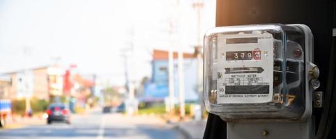 medidor de vatios-hora de electricidad colgado en el poste de cemento al lado de la carretera para monitorear y medir el uso de energía en cada casa en los países asiáticos. foto