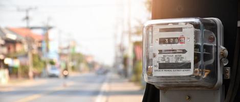 medidor de vatios-hora de electricidad colgado en el poste de cemento al lado de la carretera para monitorear y medir el uso de energía en cada casa en los países asiáticos. foto