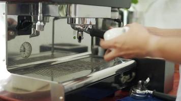 barista prepara café antes de preparar café. el dueño de una pequeña cafetería está preparando café con granos de café para servir a los clientes. nuevo barista para cafetera.