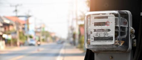 medidor de vatios-hora de electricidad colgado en el poste de cemento al lado de la carretera para monitorear y medir el uso de energía en cada casa en los países asiáticos. foto