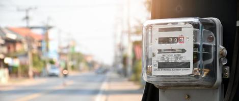 medidor de vatios-hora de electricidad colgado en el poste de cemento al lado de la carretera para monitorear y medir el uso de energía en cada casa en los países asiáticos. foto