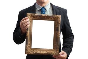 A blank diploma or a mockup certificate in the hand of a male employee wearing a black suit on white background with a clipping path. The vertical picture frame is empty. selective focus.