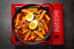 Cheesy Tokbokki korean traditional food on black board background. Lunch dish. photo