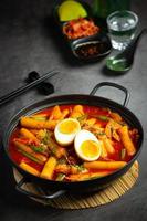 Cheesy Tokbokki korean traditional food on black board background. Lunch dish. photo