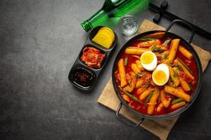 Cheesy Tokbokki korean traditional food on black board background. Lunch dish. photo